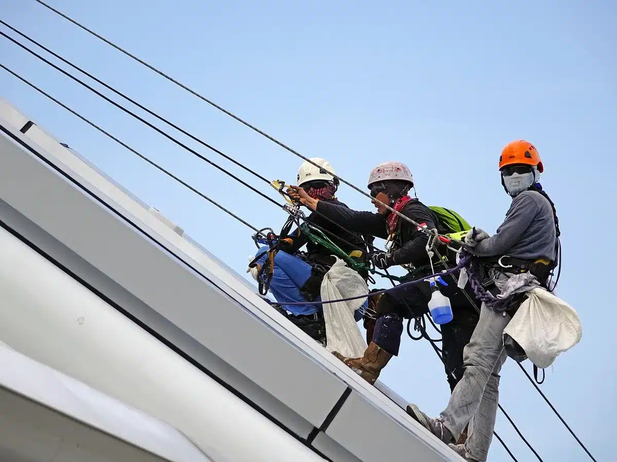 Technicien ou propriétaire consultant une checklist devant une chaudière dans une pièce claire