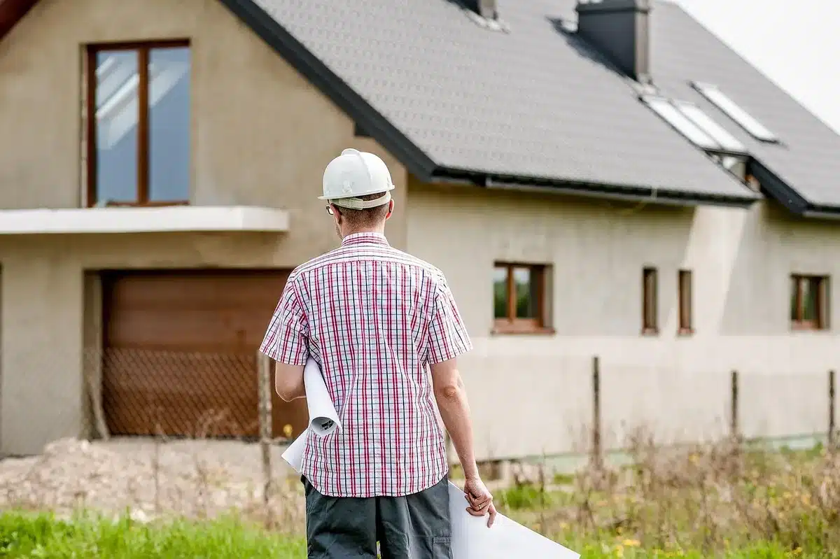 Artisan prenant des notes sur un chantier de maison ancienne, vérification des structures