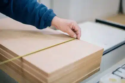Mesure d'une microfissure sur un mur intérieur avec règle et carnet de suivi