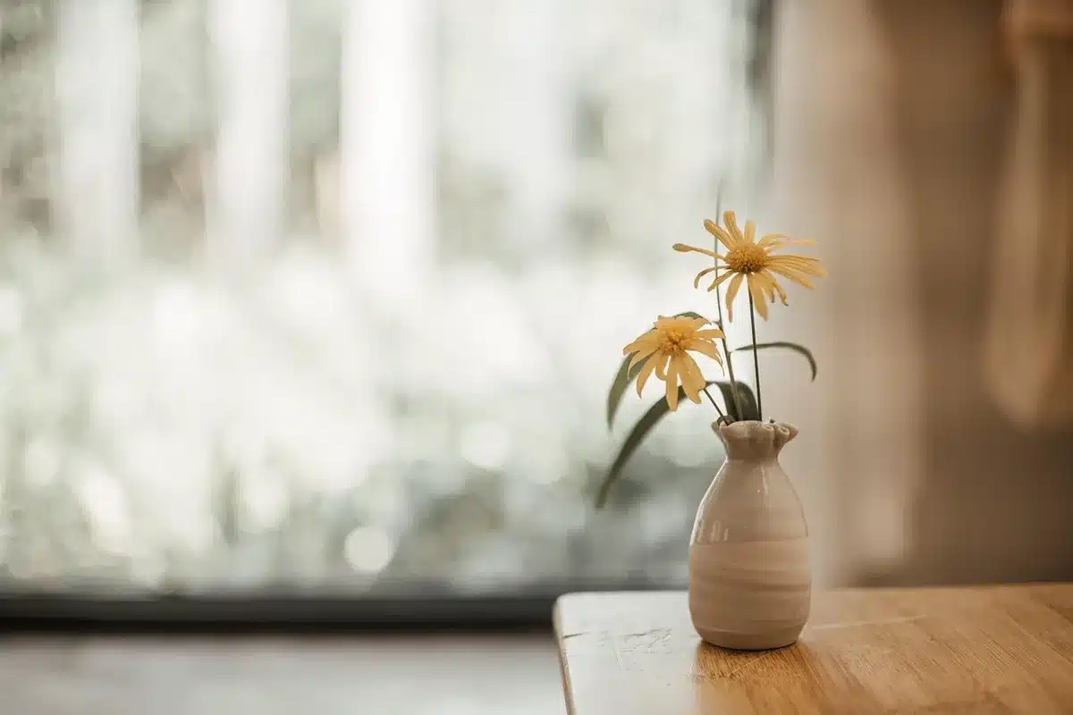 Vase en verre ambré posé sur une console en bois clair