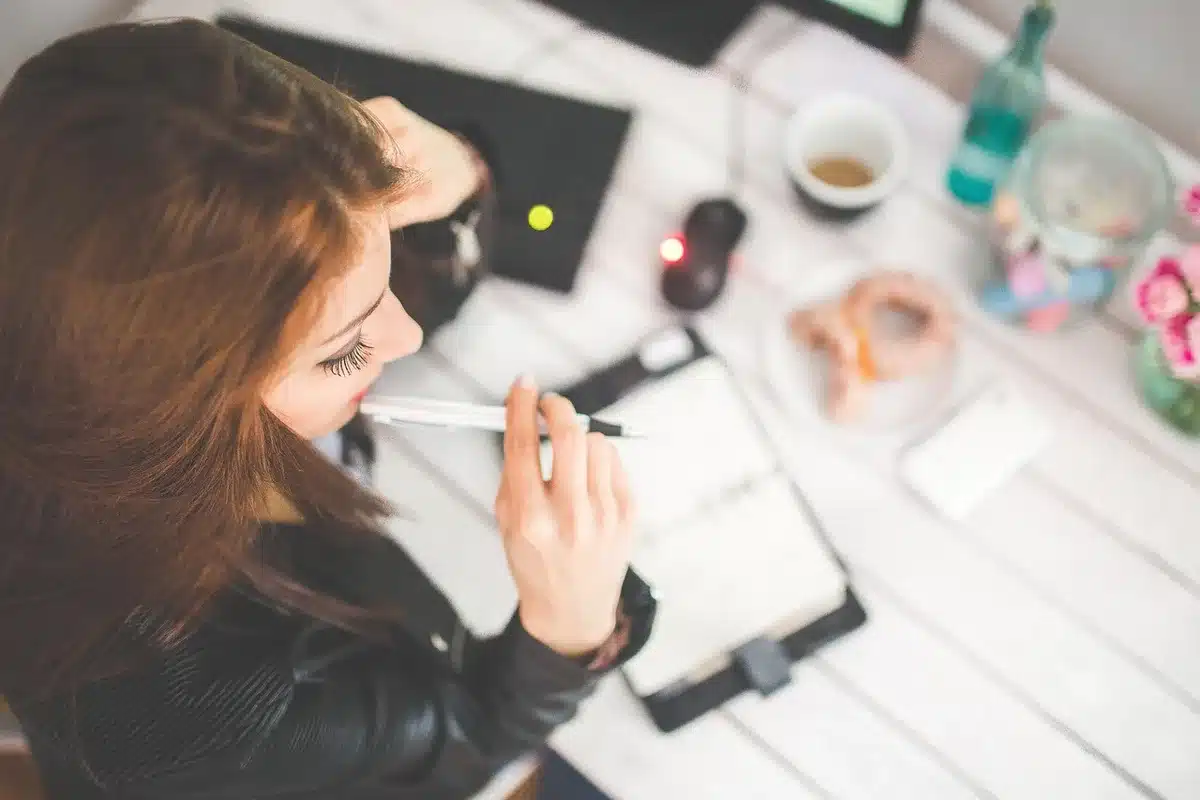 Carnet et stylo sur une table avec brochures, prise de notes sur le besoin d'achat