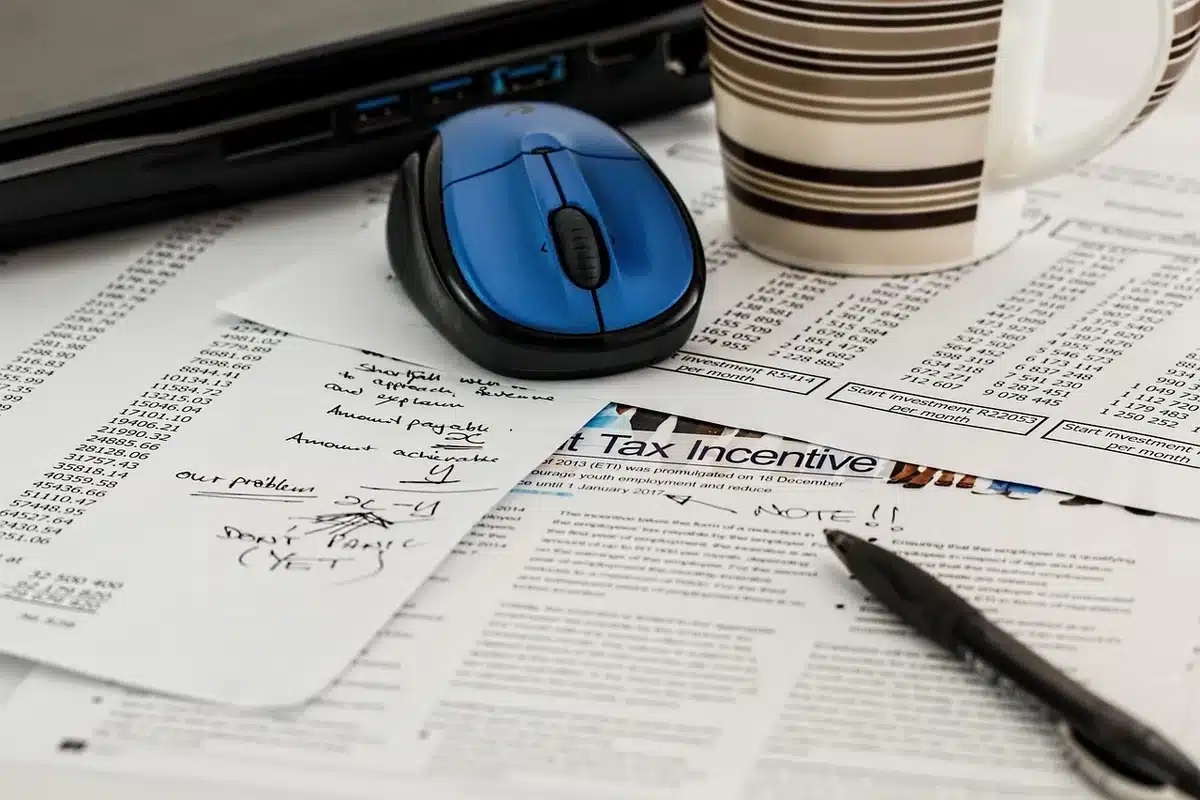 Calculatrice et fiches techniques sur un bureau pour évaluer le coût total d'usage