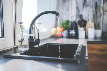 Panier à linge en osier près d'une fenêtre, lumière du jour, linge plié à côté