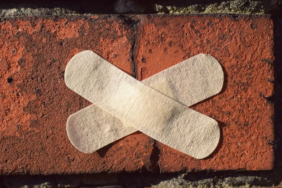 Mur avec auréole d'humidité et papier peint qui se décolle