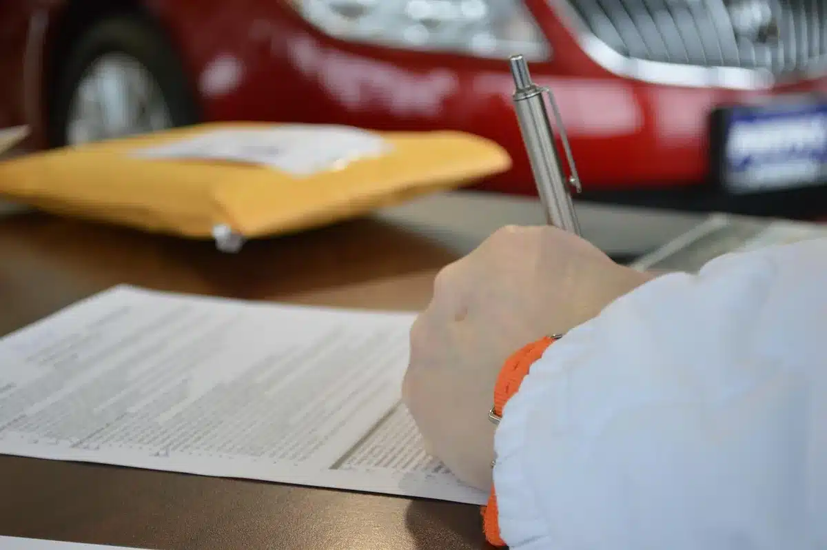 Personne signe un devis de rénovation sur un bureau en journée