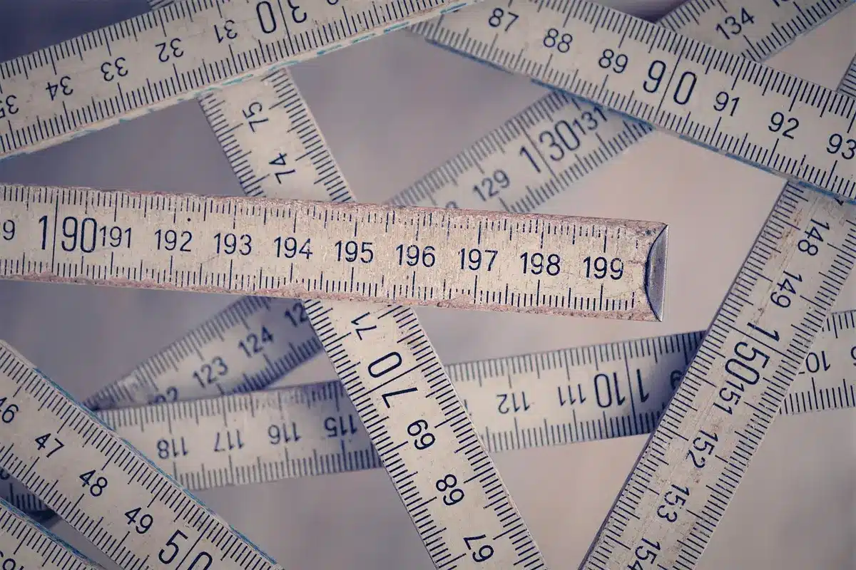 Outils de mesure (règle et niveau) posés sur une marche pour vérifier l'état